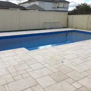 pool with classic travertine crazy design coping