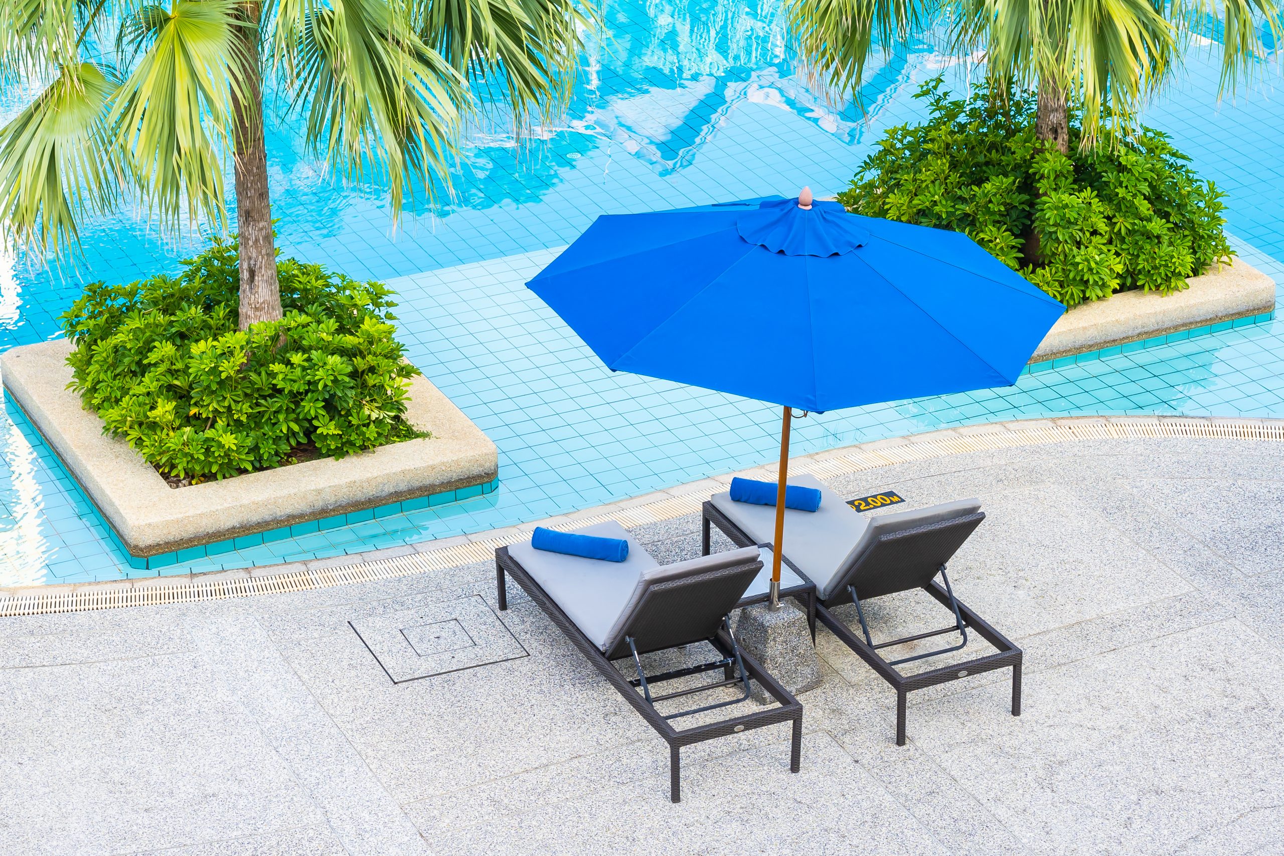 Umbrella and chair around outdoor swimming pool